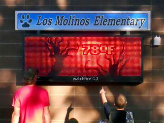 Two people looking at the Los Molinos Elementary School LED Board